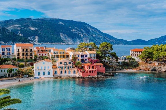 Beautiful, colorful, coastal town in Greece with clear blue waters and a mountainous backdrop