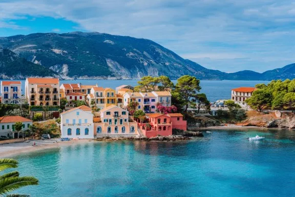Beautiful, colorful, coastal town in Greece with clear blue waters and a mountainous backdrop