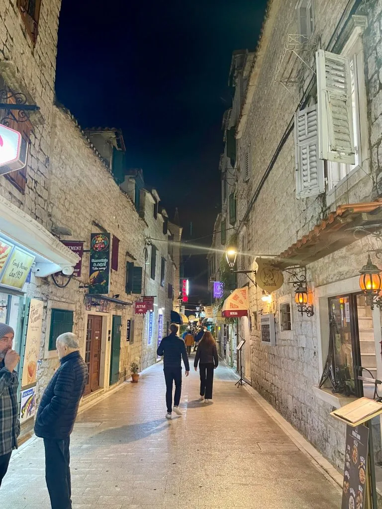 Walking through Trogir's lit stone streets at night