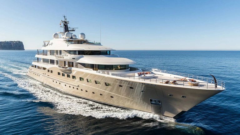 Crewed superyacht at anchor with charter guests