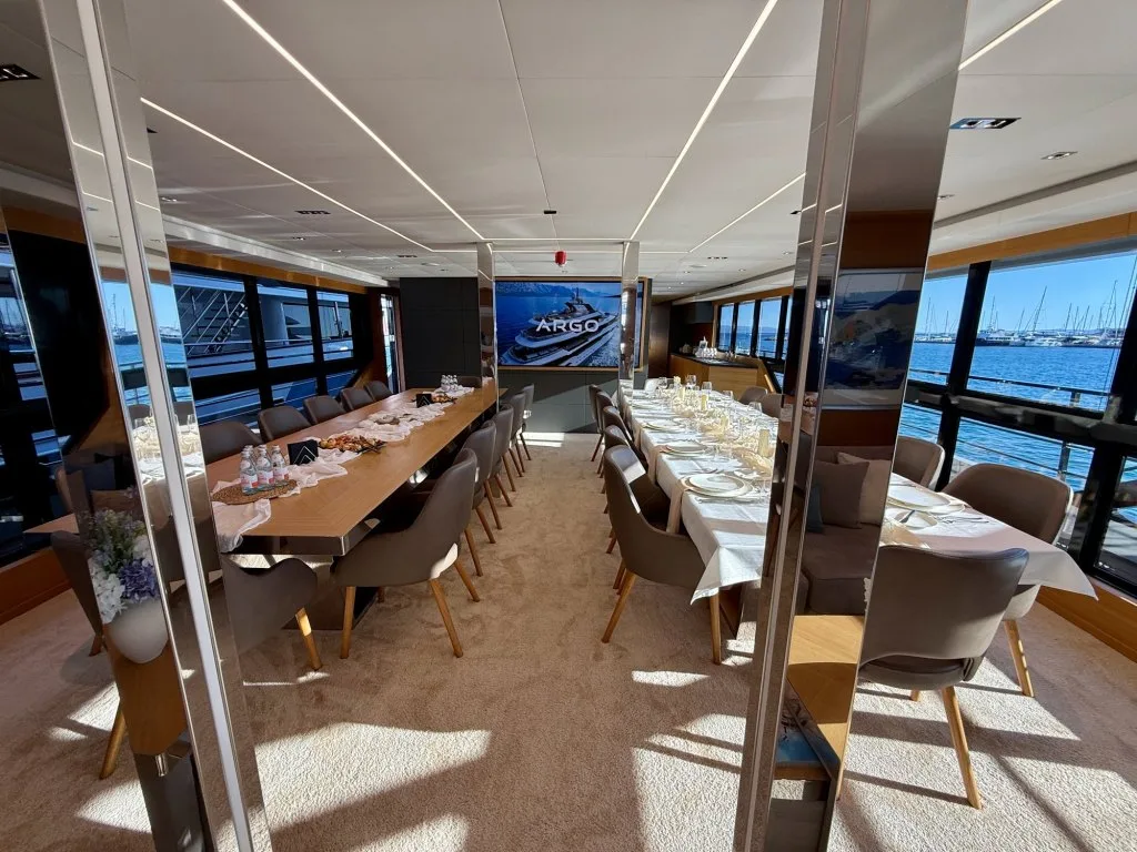 The long interior dining table on motor yacht ARGO laid for a full group of guests, Split, September 2026.