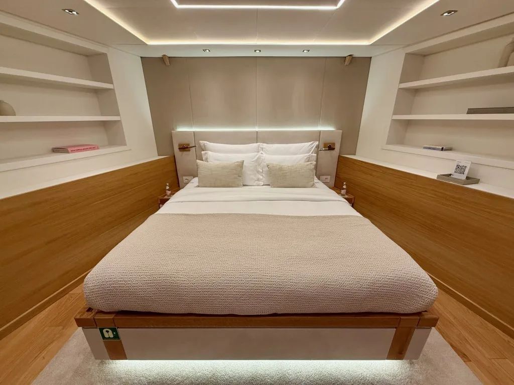A standard double guest cabin on the lower deck of motor yacht ARGO, light oak with built-in shelving, September 2026.
