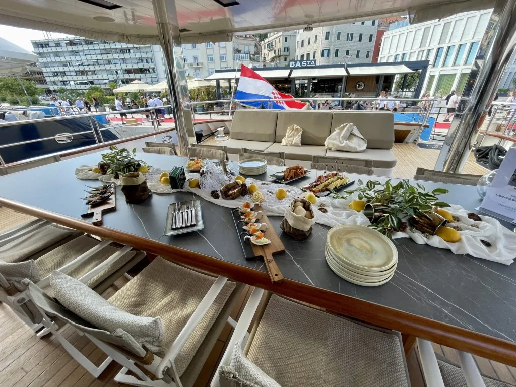 Canapés laid out on the aft-deck table of MARALLURE, Croatian flag astern