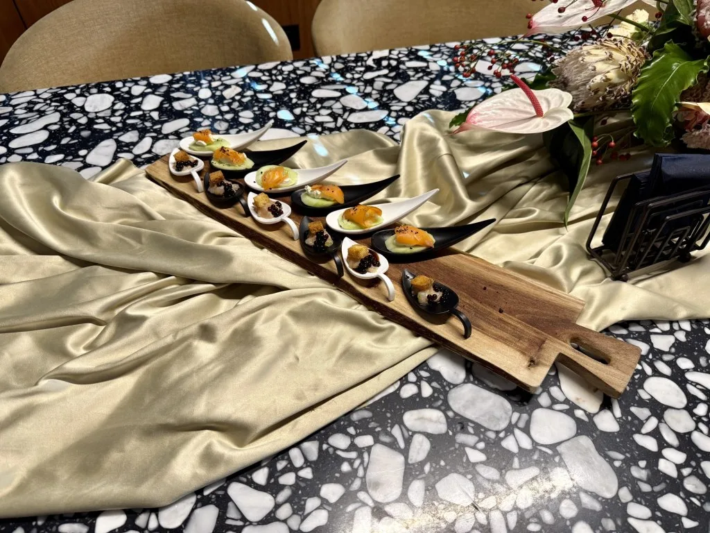 Canapés on the terrazzo dining table of MARALLURE