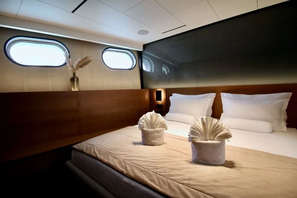 MARALLURE VIP cabin with towel art on the bed and portholes on the hull side
