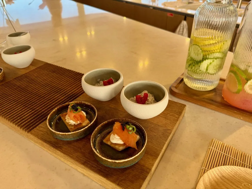 Small Japanese-style canapés in ceramic dishes served on the cooking island of catamaran MIDORI, September 2026.