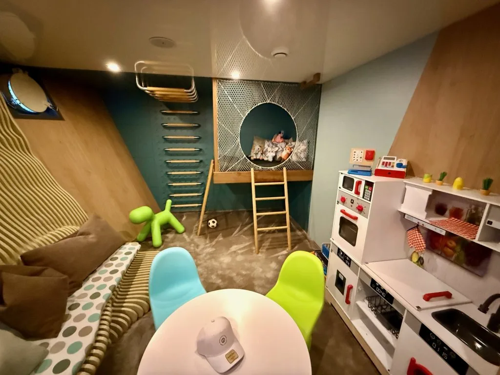 The children's playroom on motor yacht OHANA with a climbing wall, monkey bars, a slide and a toy kitchen, September 2026.