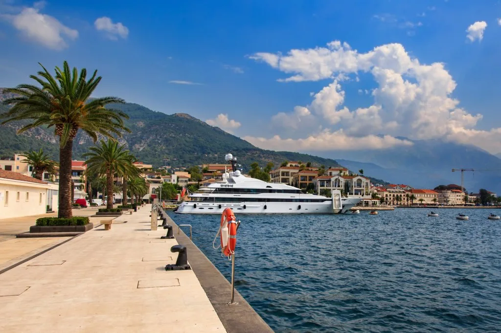 Large motor yacht moored along the palm-lined quay at Porto Montenegro in Tivat, Montenegro