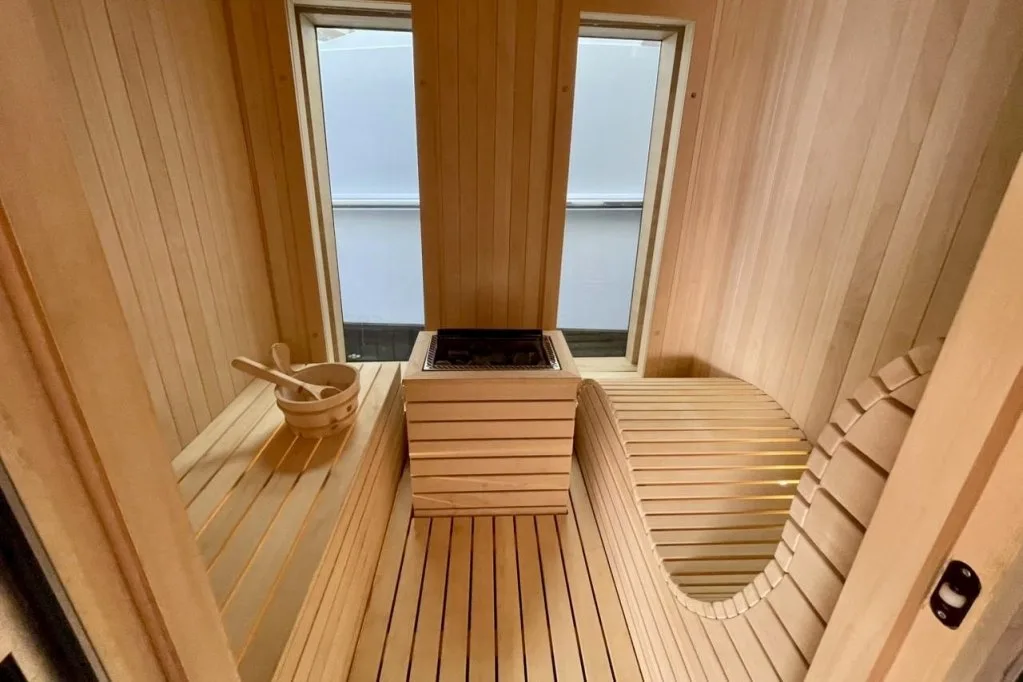 The wood-lined sauna in the beach club of motor yacht RENATA, with a window to the sea, September 2026.