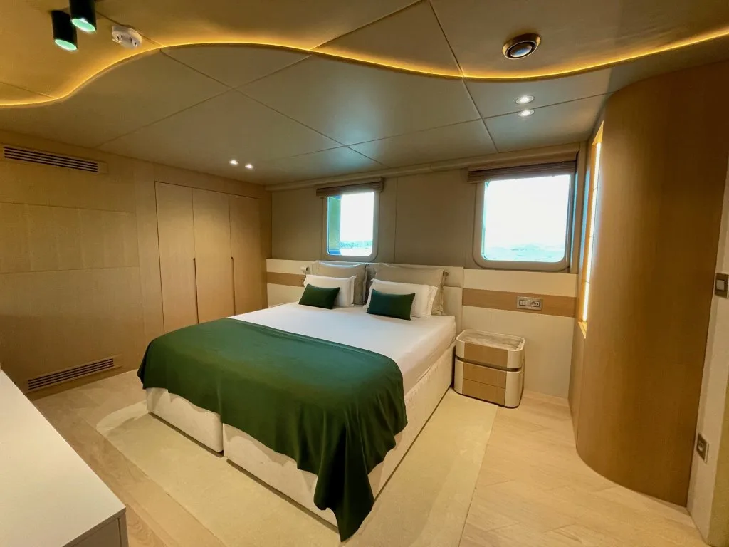 A double guest cabin on motorsailer REPOSADO with a green throw and a window, September 2025.