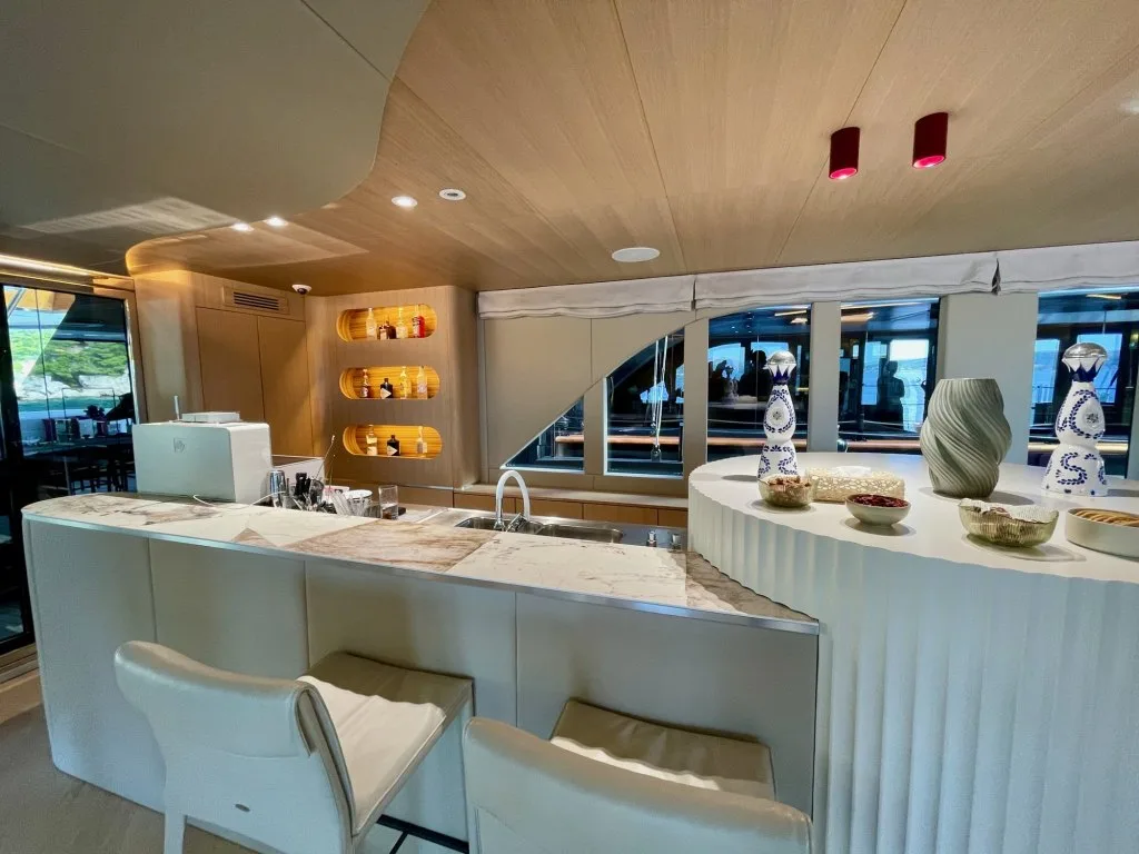 The bar in the saloon of motorsailer REPOSADO with stools and lit shelving, September 2025.