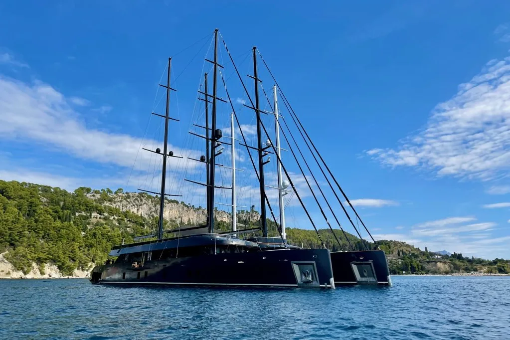 The stern quarter of the motorsailer REPOSADO at anchor off Split, dark hull and swim platform, September 2025.