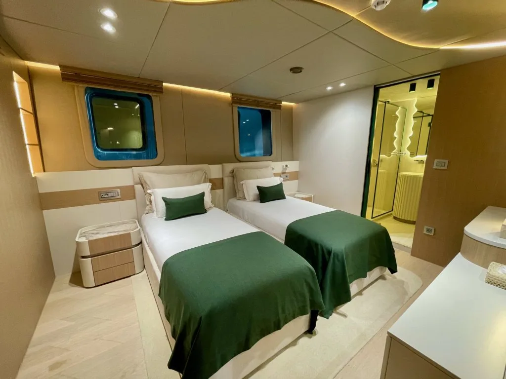 A twin guest cabin on motorsailer REPOSADO with two beds and green throws, September 2025.